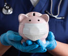 clinician holding piggy bank wearing medical mask