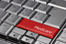 Red Medicare key on black and white keyboard